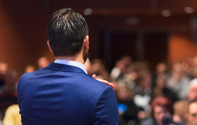 Man speaking to a large audience